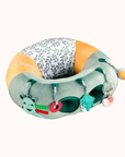 Sophie La Girafe Baby Seat featuring green and yellow patterns and toys to stimulate baby's senses