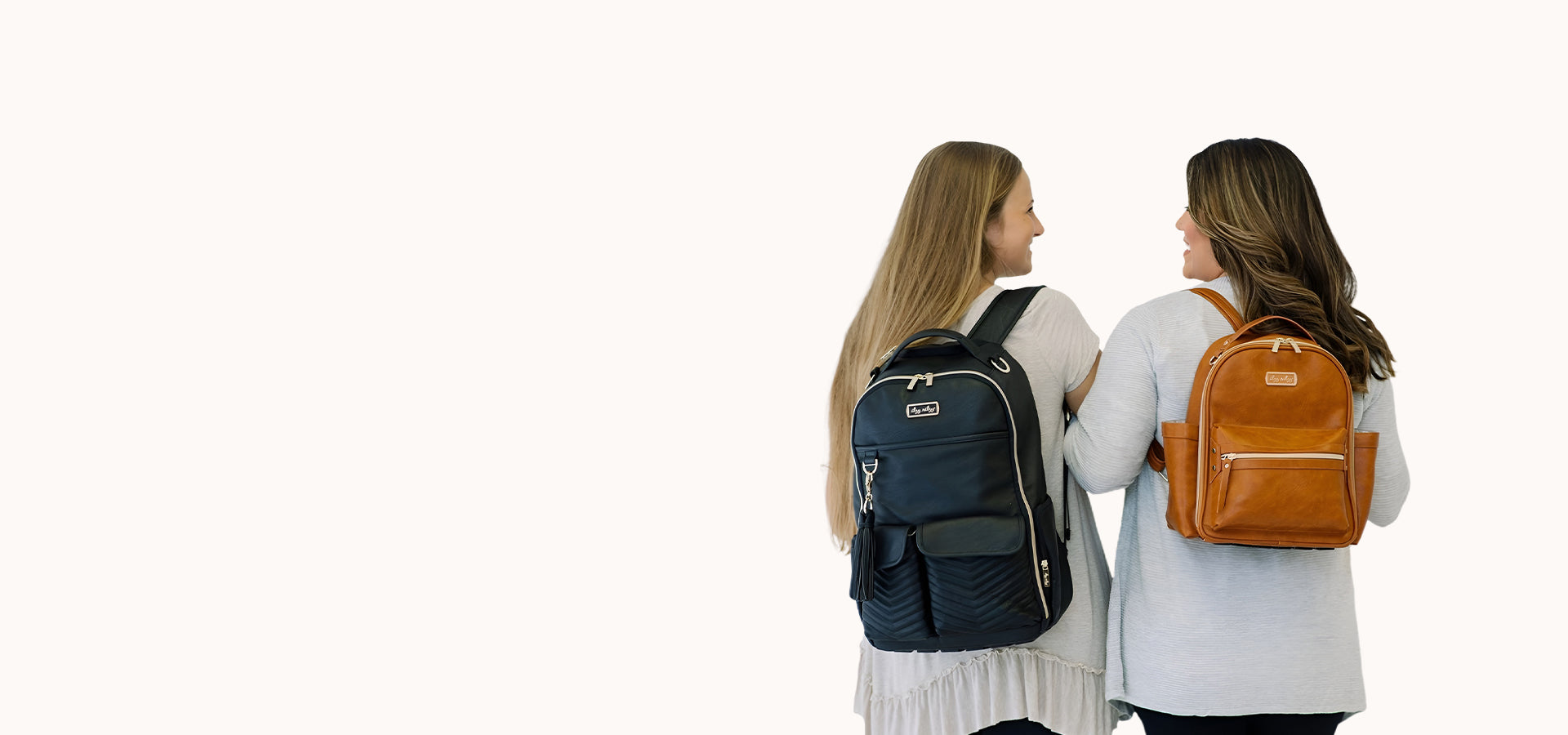 Image of two women standing next to each other, carrying backpacks