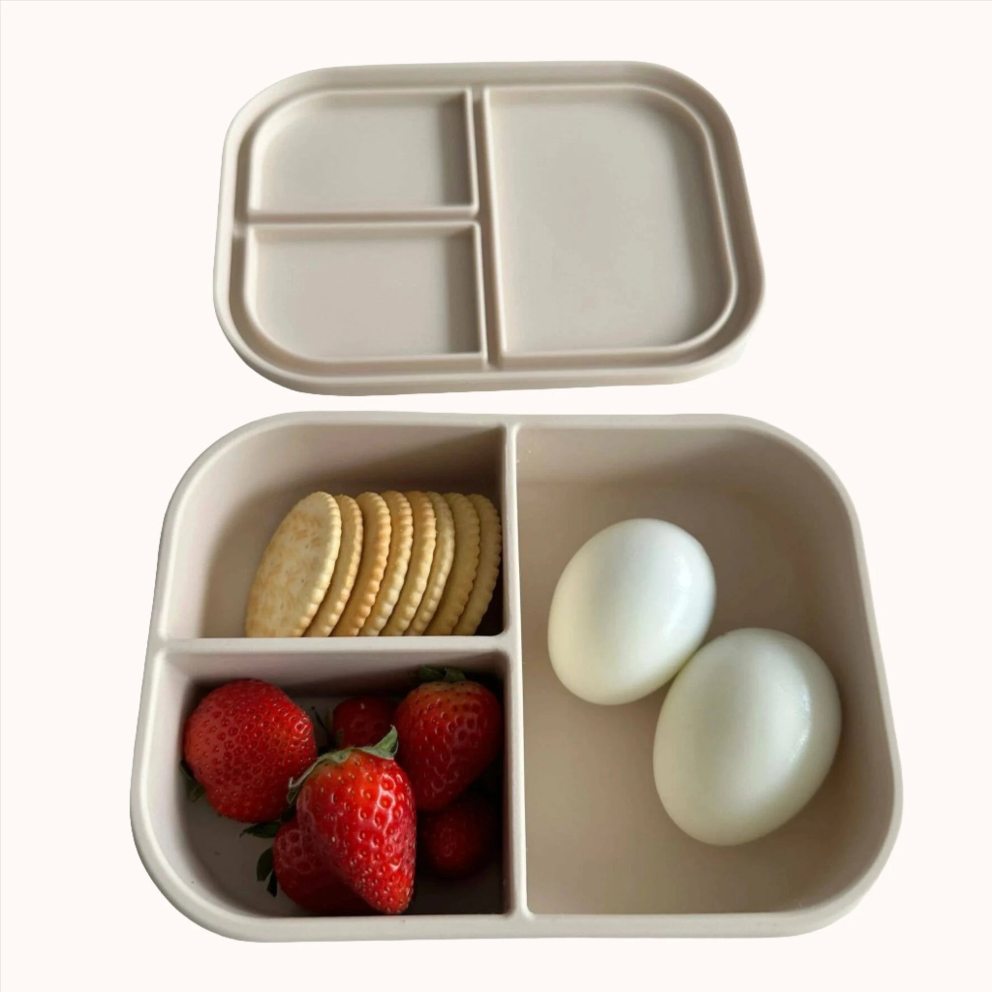 Ali+Oli Coco bento box filled with strawberries, boiled eggs, and crackers