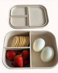 Ali+Oli Coco bento box filled with strawberries, boiled eggs, and crackers