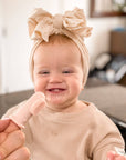 Infant girl happily using her pink finger toothbrush during teething