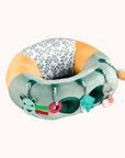 Close-up of the Sophie La Girafe Baby Seat featuring green and yellow patterns