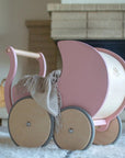 Rose Kinderfeets wooden pram with a cozy blanket inside, placed on the floor