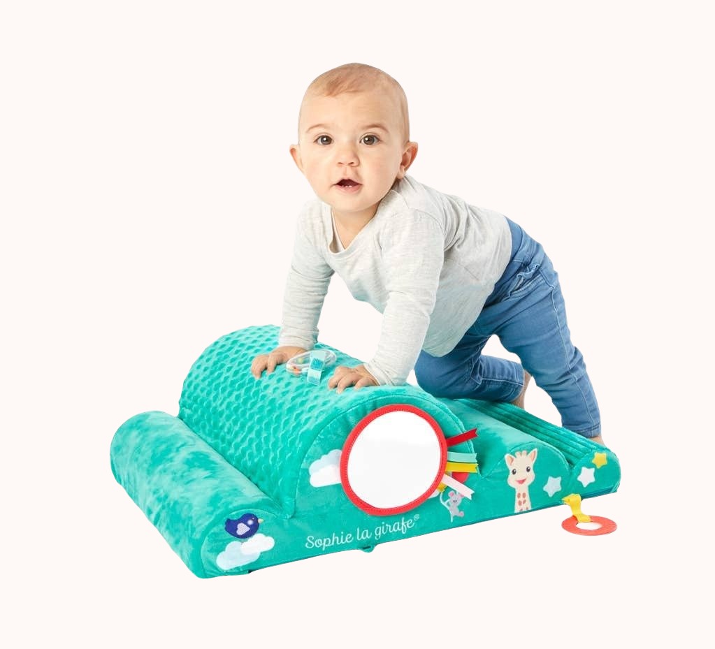 Infant engaging with Sophie La Girafe activity mat featuring a Giraffe illustration