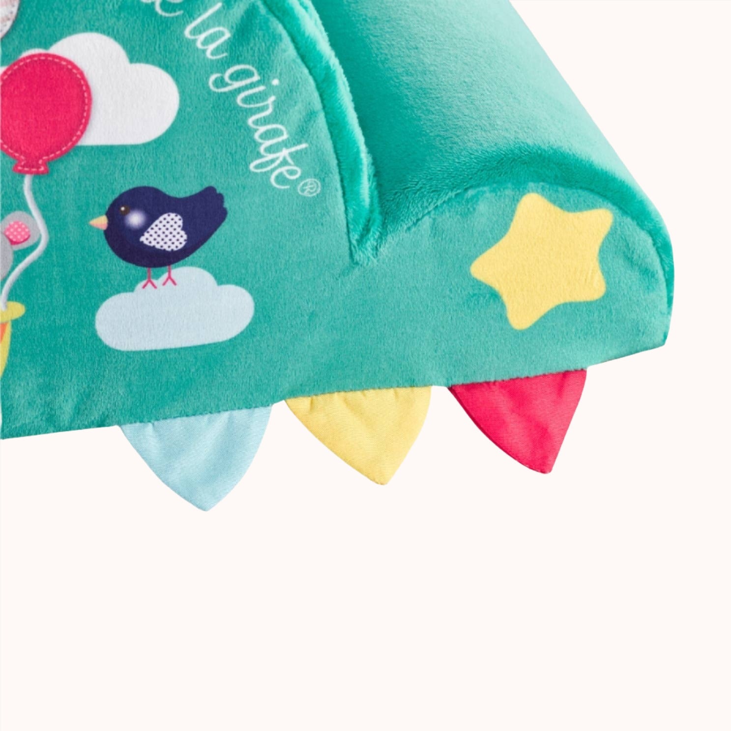 Sophie La Girafe baby pillow decorated with a bird and cloud designs