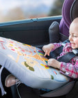 Baby in the car smiling while playing with Sophie la Girafe Touch & Play Board on his lap
