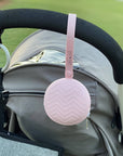 ALI + OLI pacifier holder attached to a stroller in pink color