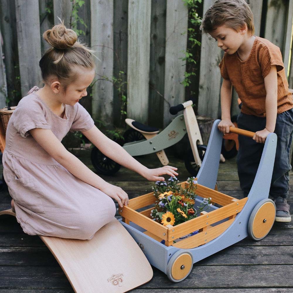 Slate blue Kinderfeets Cargo Walker being used by two children outdoors